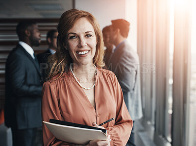 Buy stock photo Portrait of a professional businesswoman standing in an office with colleagues in the background