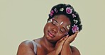 Face, flowers and beauty with a body positive black woman in studio on a gray background for natural wellness. Portrait, skincare and a confident young plus size model feeling her aesthetic skin