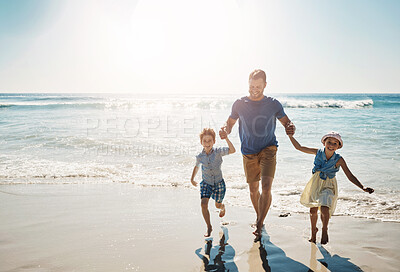 Buy stock photo Shot of a father bonding with his two little children at the beach