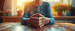 Close up, elderly and hands. Portrait, senior and sitting at kitchen table. Retirement, helpful and healthcare concept. Wellbeing, depression and caregiving with background sunlight through window