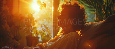 Depressed, elderly and woman at home. Senior, female and mental health concept in the living room. Sadness, longing and remembering sitting on couch with sunset background and reminiscing about past.