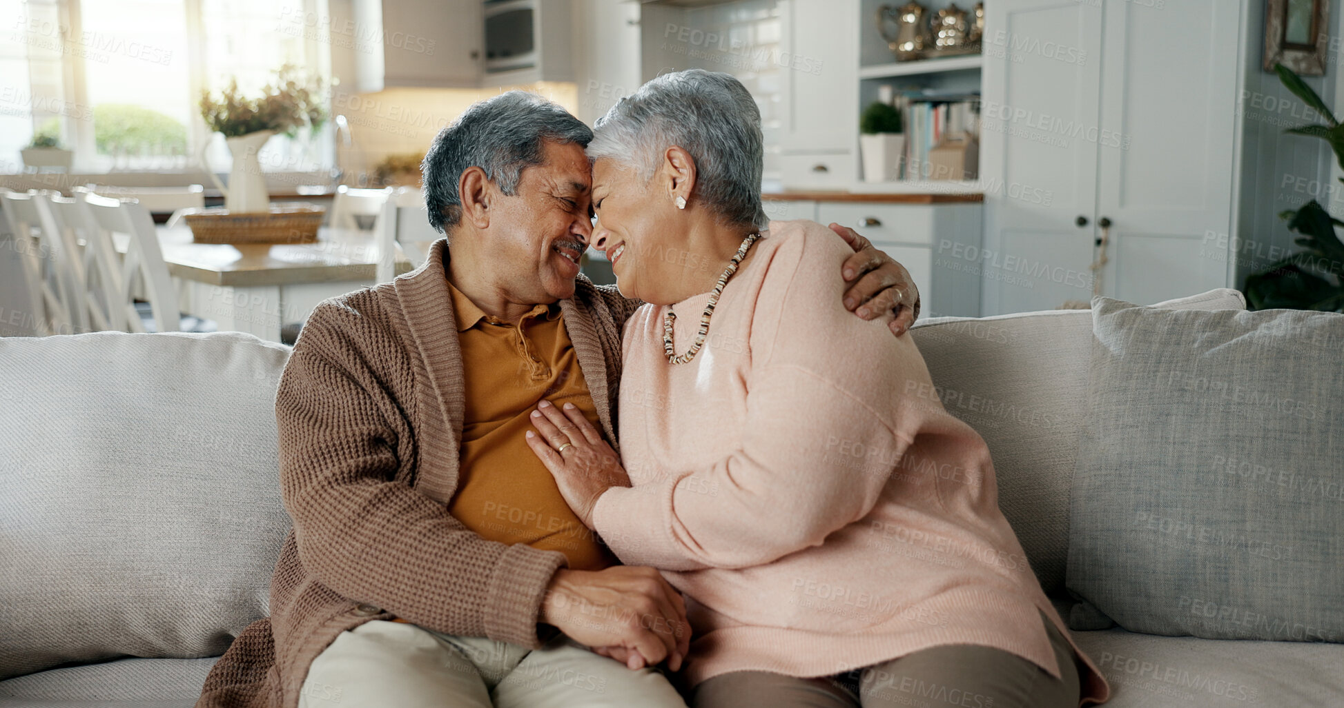 Buy stock photo Senior couple, face and hug on sofa, smile and bonding with love, support and relax in retirement in home. Elderly woman, old man and happy with embrace, together and sitting on living room couch