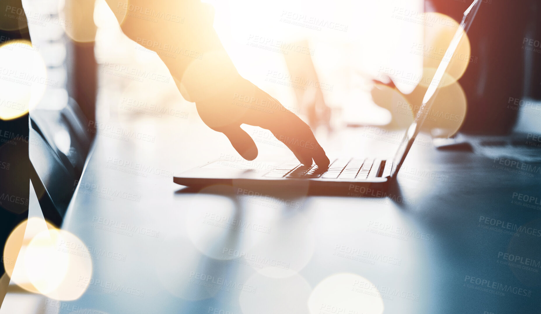 Buy stock photo Silhouetted shot of an unrecognizable businessman using a laptop in an office