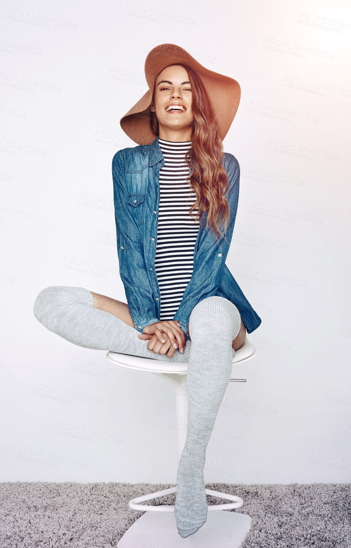 Buy stock photo Fashion, smile and portrait of woman on stool in studio with stylish, trendy and casual outfit for confidence. Happy, chair and female person from Canada with hat and chic clothes by white background