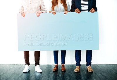 Buy stock photo Cropped studio shot of a group of people holding a blank placard against a white background