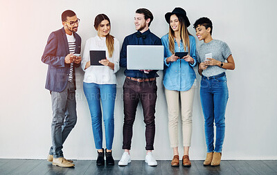 Buy stock photo Shot of a group of creative employees using wireless technology while standing in line
