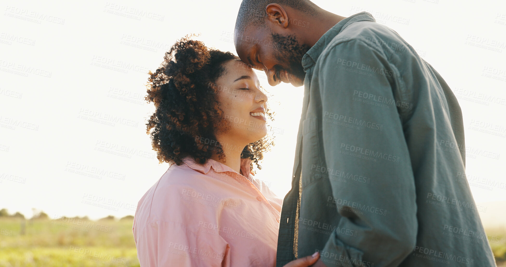 Buy stock photo Couple, sunlight and forehead touch in nature for bonding together, love and happy in marriage. Interracial people, holiday and commitment in relationship, partnership and hug or loyal in outdoors