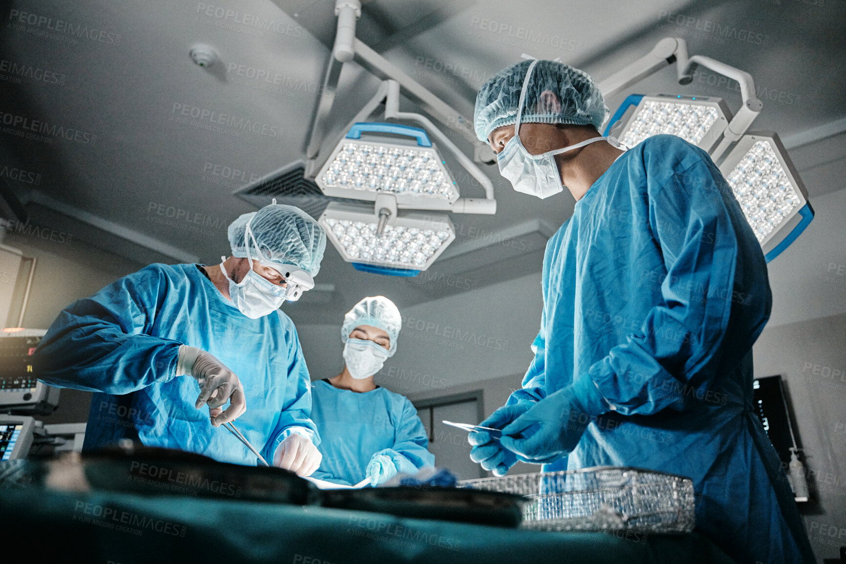 Buy stock photo Surgeon group, procedure and operating room at hospital in scrubs, ppe and tools for healthcare emergency. Doctors, teamwork and together in icu, medical surgery and services for wellness at clinic