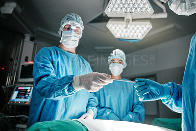 Doctors, hands and scalpel in operating room at hospital in scrubs, ppe or emergency surgery for health. Surgeon, group and together in icu, medical procedure or giving tools for wellness at clinic