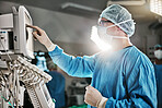 Surgery, machine and doctor with monitor in theatre for healthcare, cardiovascular operation or analysis. Medical professional, man and scrubs with equipment for cardiology, procedure or information