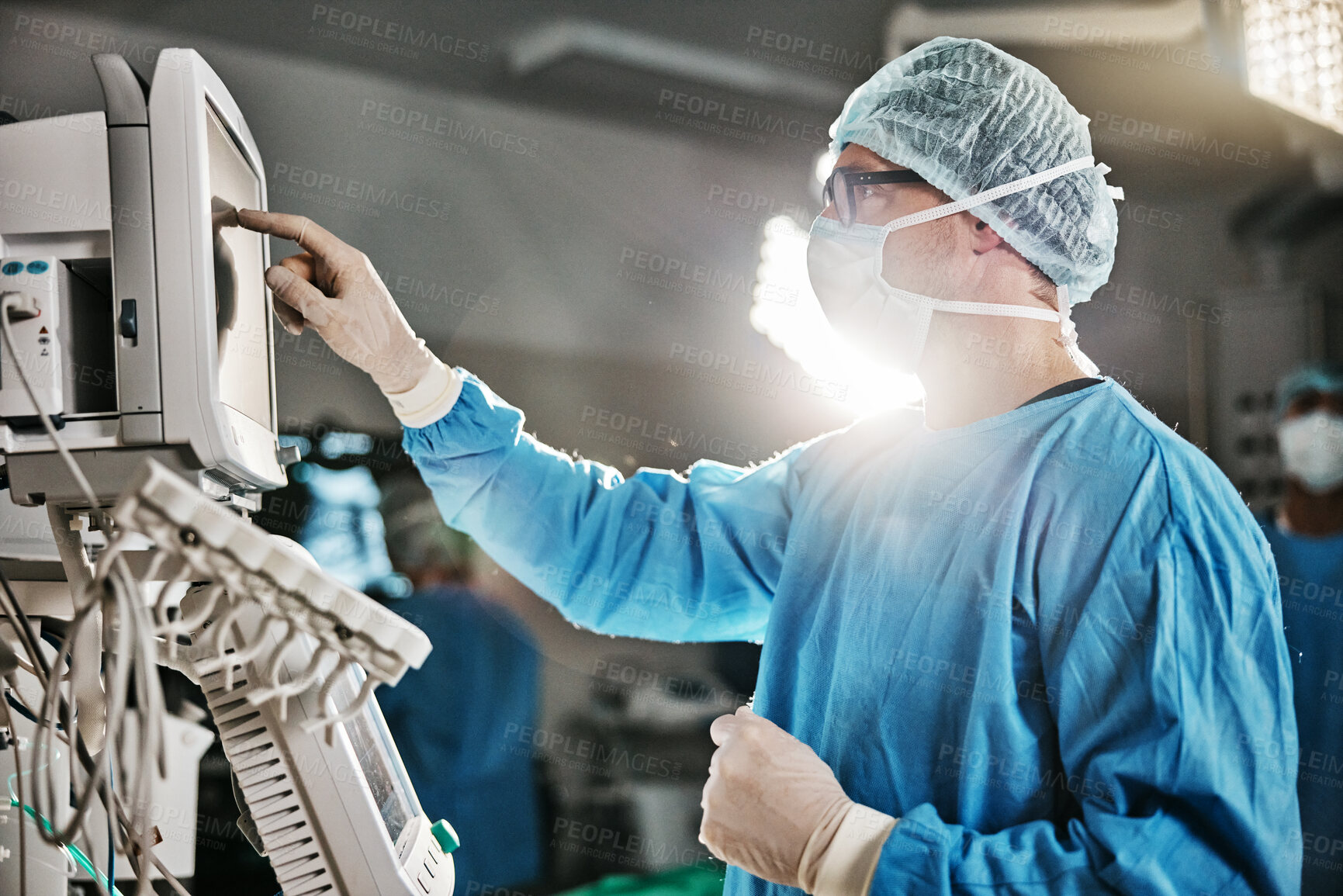 Buy stock photo Surgery, machine and doctor with monitor in theatre for healthcare, cardiovascular operation or analysis. Medical professional, man and scrubs with equipment for cardiology, procedure or information