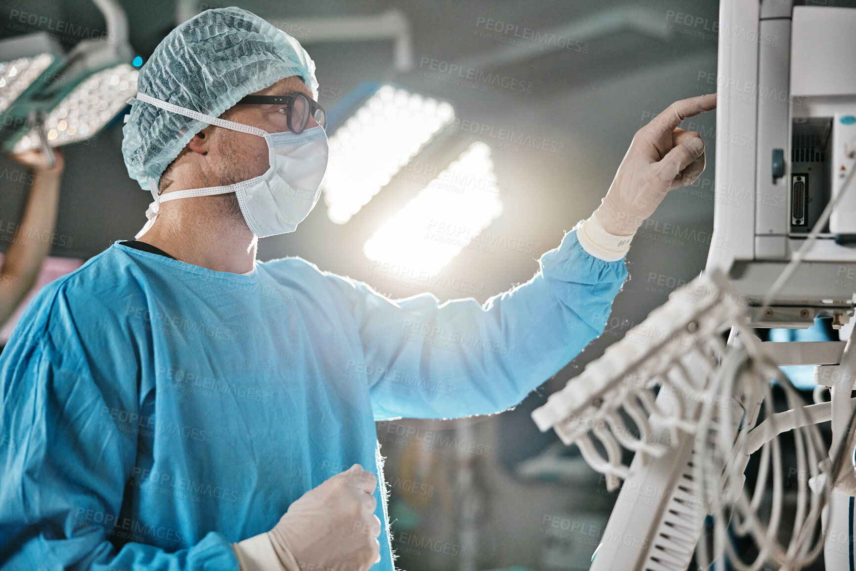 Buy stock photo Surgery, machine and doctor with monitor in hospital for healthcare, theatre operation or analysis. Medical, man and surgeon in scrubs with digital technology for cardiology, procedure or information