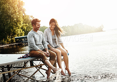 Buy stock photo Vacation, couple and sitting on dock in nature for holiday, fun and splashing feet in water in summer. Happiness, people and romantic getaway by lake for adventure, commitment or love in relationship