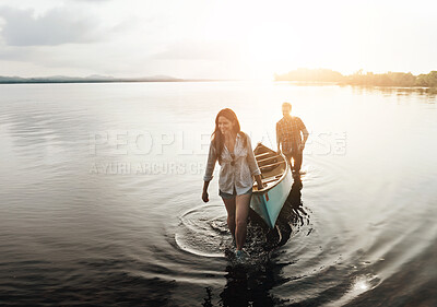 Buy stock photo Shot of a young couple coming from a canoe ride on the lake