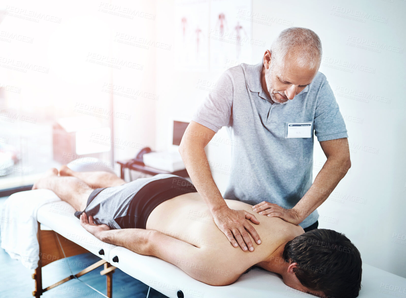 Buy stock photo Physical therapist, men and patient with back massage, injury and consultation for recovery, healing and expert. People, chiropractor and client with physiotherapy, specialist with skill and wellness