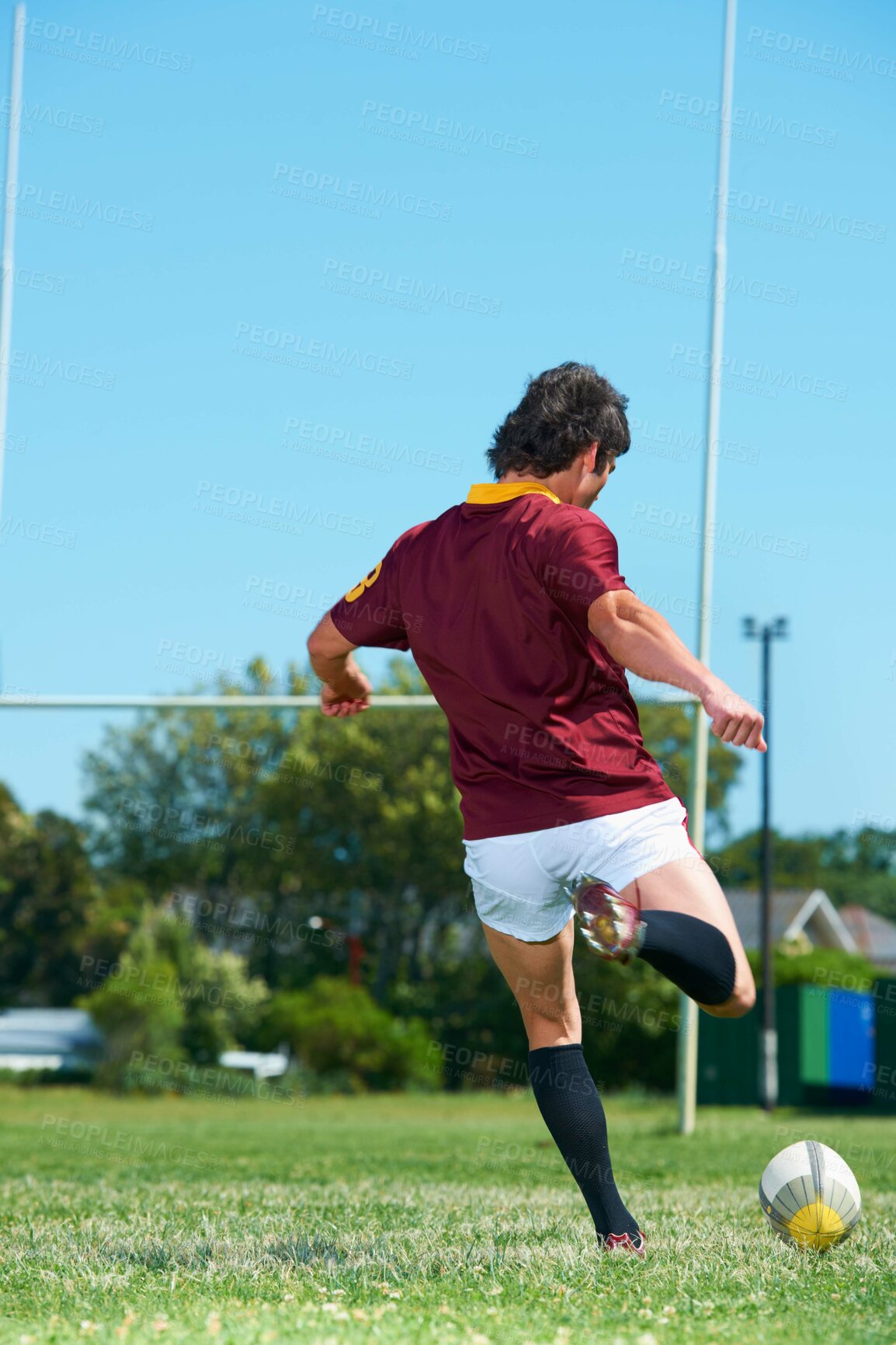 Buy stock photo Back, kick and man playing with rugby ball on a grass field to score during workout. Athlete, sport and professional player training for healthy workout in a uniform for kicking exercise with energy