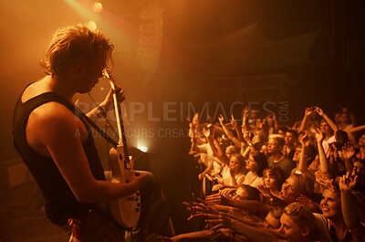 Buy stock photo Guitar, concert and crowd at stage with man in performance of rock, metal and music. Festival, event and audience of people in celebration of talent in theater at night with spotlight and energy