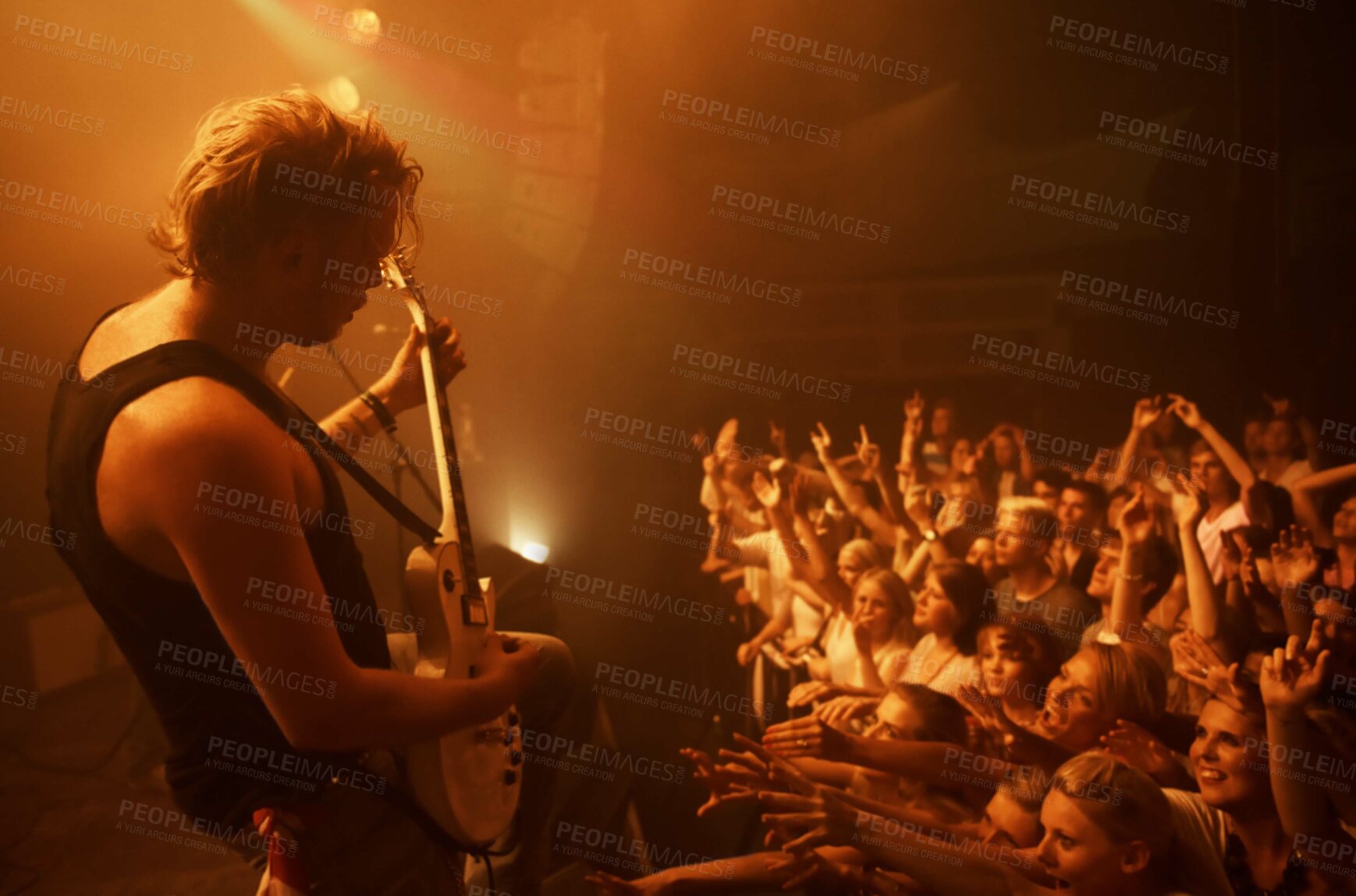 Buy stock photo Guitar, concert and crowd at stage with man in performance of rock, metal and music. Festival, event and audience of people in celebration of talent in theater at night with spotlight and energy