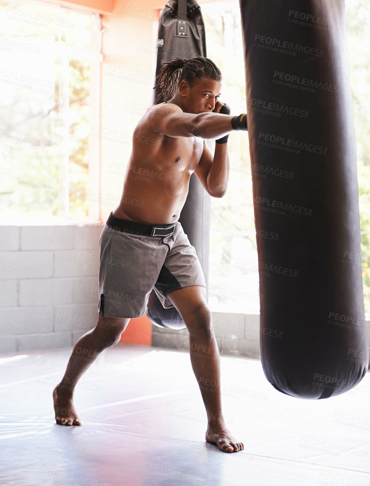 Buy stock photo Fitness, punching bag and black man in gym for body exercise, boxing challenge or competition training. Power, muscle and champion boxer at workout with confidence, fight and energy in sports club.
