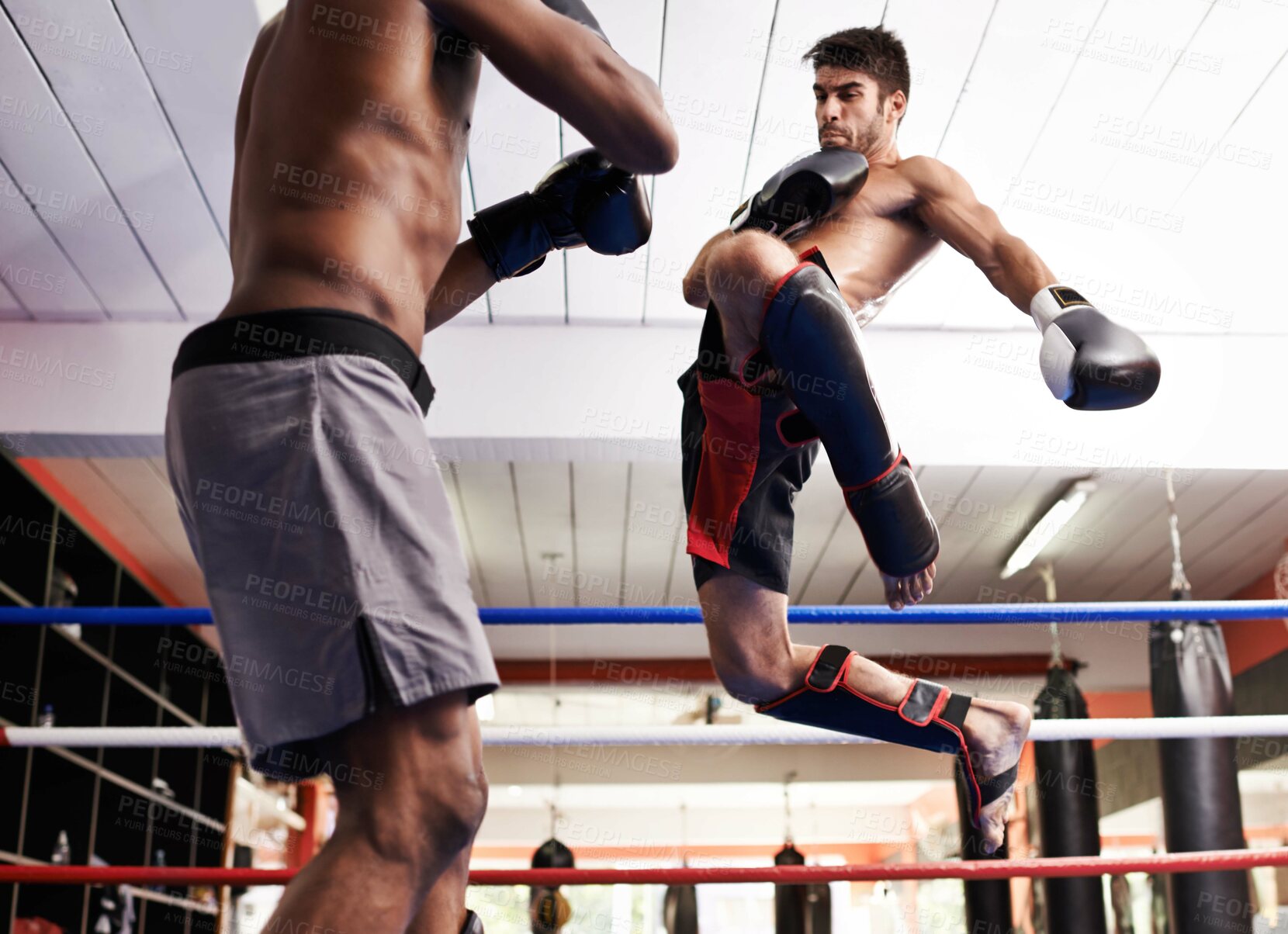 Buy stock photo Kickboxing, jump in fight and men training for fitness and sport in gym, coach and athlete with workout and action. Energy, challenge and MMA with athlete in ring for boxing, exercise and endurance