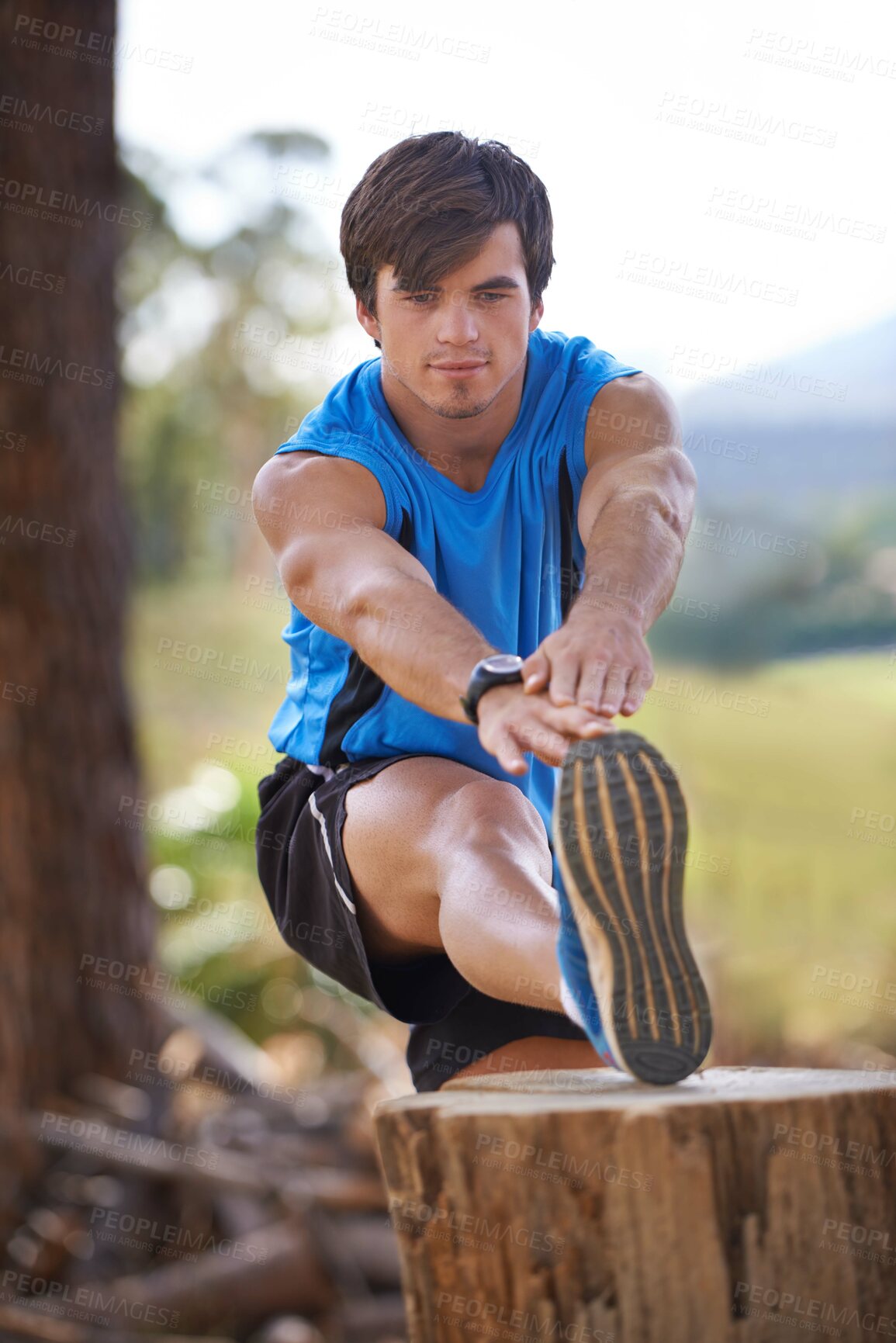 Buy stock photo Shot of a handsome young man exercising outdoors