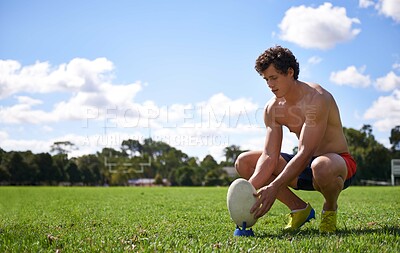 Buy stock photo Man, rugby ball and ready to kick on grass with thinking, aim and target for challenge, training and fitness. Athlete, person and prepare for sports, games and workout on field with vision for goal