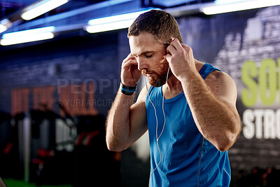 Buy stock photo Gym, man or listen to music, motivation or fitness podcast to focus on workout, training or exercise. Earphones, guy or audio to relax, warm up or confident of cardio as vision of health and wellness