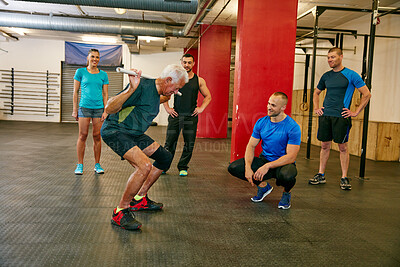 Buy stock photo Shot of a senior man doing pvc exercises while a group of people watch on
