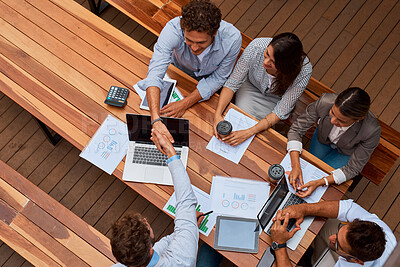 Buy stock photo High angle shot of businesspeople shaking hands during a meeting outdoors