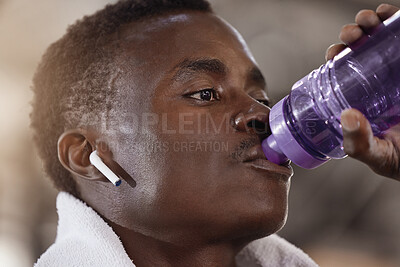 Buy stock photo Gym, earphones and fitness man drinking water for training, break or hydration for body recovery after intense exercise. Sports, drink or African athlete streaming, music or pause for hydrogen liquid