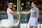 Tennis, sport and women handshake for competition, fitness and exercise on outdoor tennis court for health and active life. Athlete, friendly and competitive, smile with rival and ready for match.