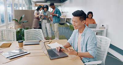 Buy stock photo Asian man in office with phone, smile and laptop for market research, email or online report at startup. Creative businessman in coworking space with computer, smartphone and job ideas at tech agency