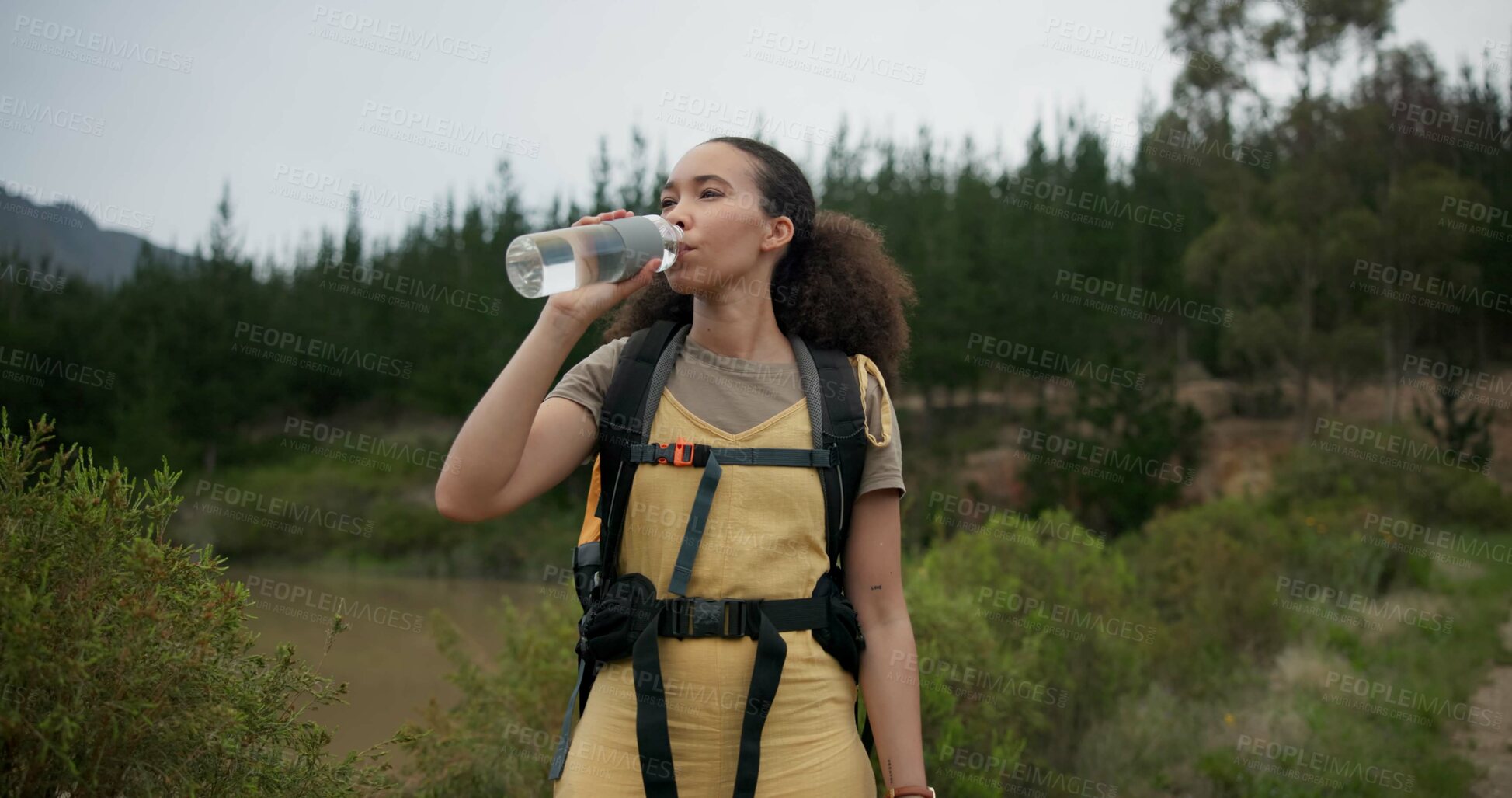Buy stock photo Hiking woman, drinking water and bottle in forest for hydration, detox or wellness on bush adventure. Girl, trekking and liquid for health in nature, woods and outdoor for fitness, exercise or summer