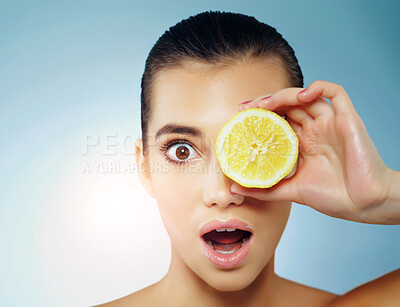 Buy stock photo Girl, portrait and lemon in studio for skincare or natural beauty, facial treatment and organic cosmetics ingredient. Woman, blue background and wow with fruit for healthy skin, results and vitamin c