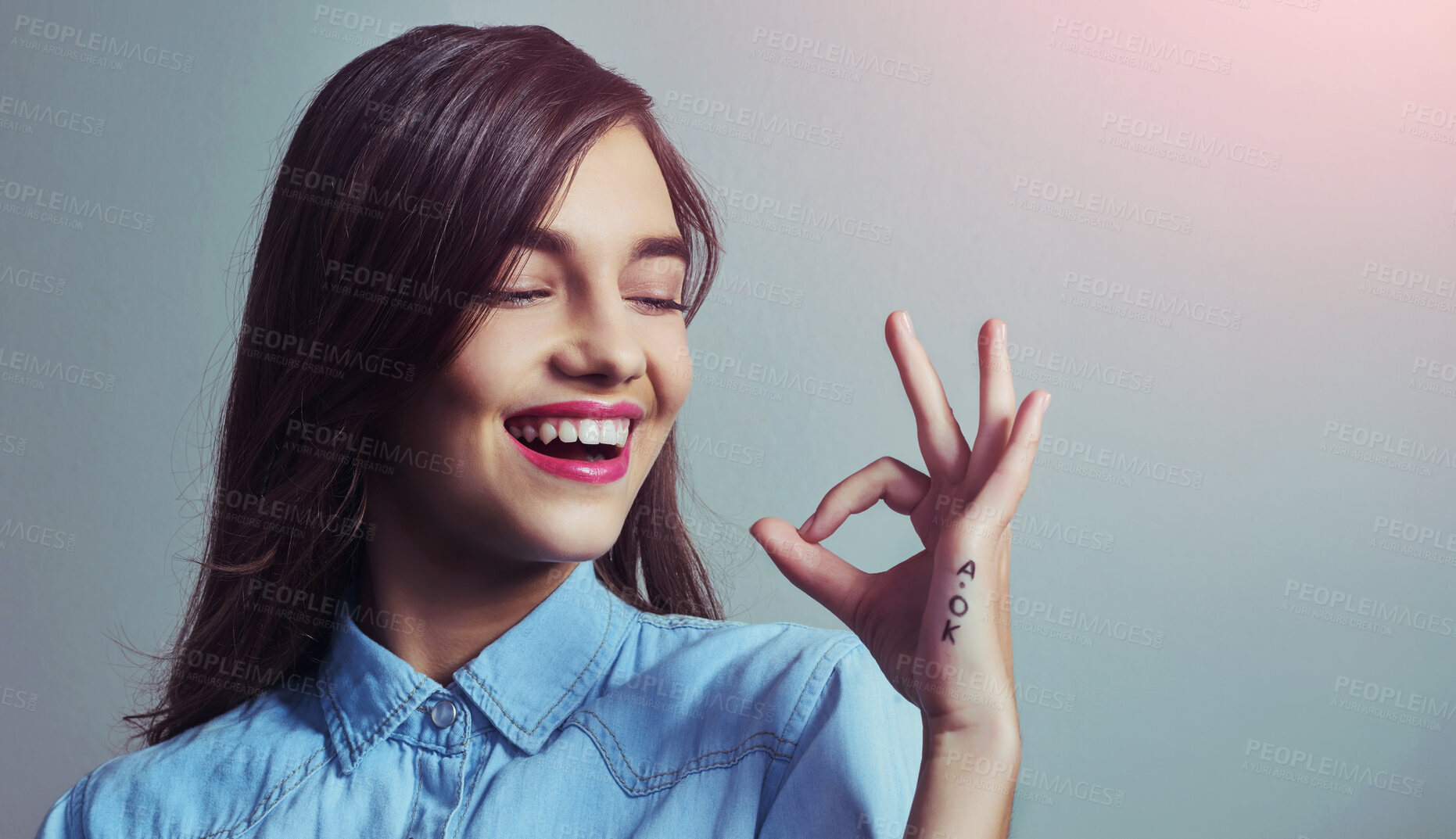 Buy stock photo Smile, perfect and woman with hand sign for agreement, opinion or like emoji in studio mockup. Happy, review and gen z girl with okay gesture for approval vote, support or yes icon on grey background