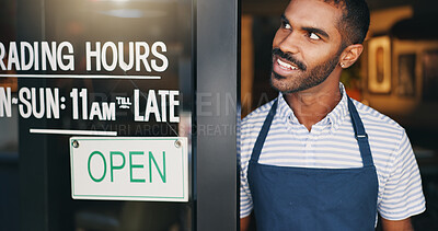 Open, sign and happy man at window of small business, coffee shop or start of service at restaurant. Store, notice and hands of owner change signage, board or information of operating time and hopeful morning