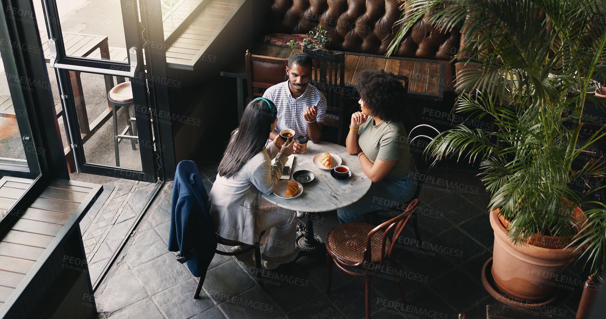 Buy stock photo Group, colleagues and talking in coffee shop or brainstorming startup idea, planning or collaboration. Man, woman and diversity teamwork with notebook or creative company vision, lunch or discussion