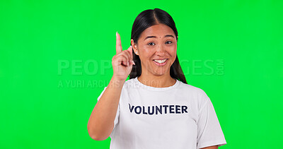Volunteer, green screen and a woman pointing at space for advertising, charity or information. Face of happy asian person with a hand and tshirt for nonprofit project, NGO help or donation in studio