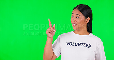 Volunteer, green screen and a woman pointing at space for advertising, charity or information. Face of happy asian person with a hand and tshirt for nonprofit project, NGO help or donation in studio