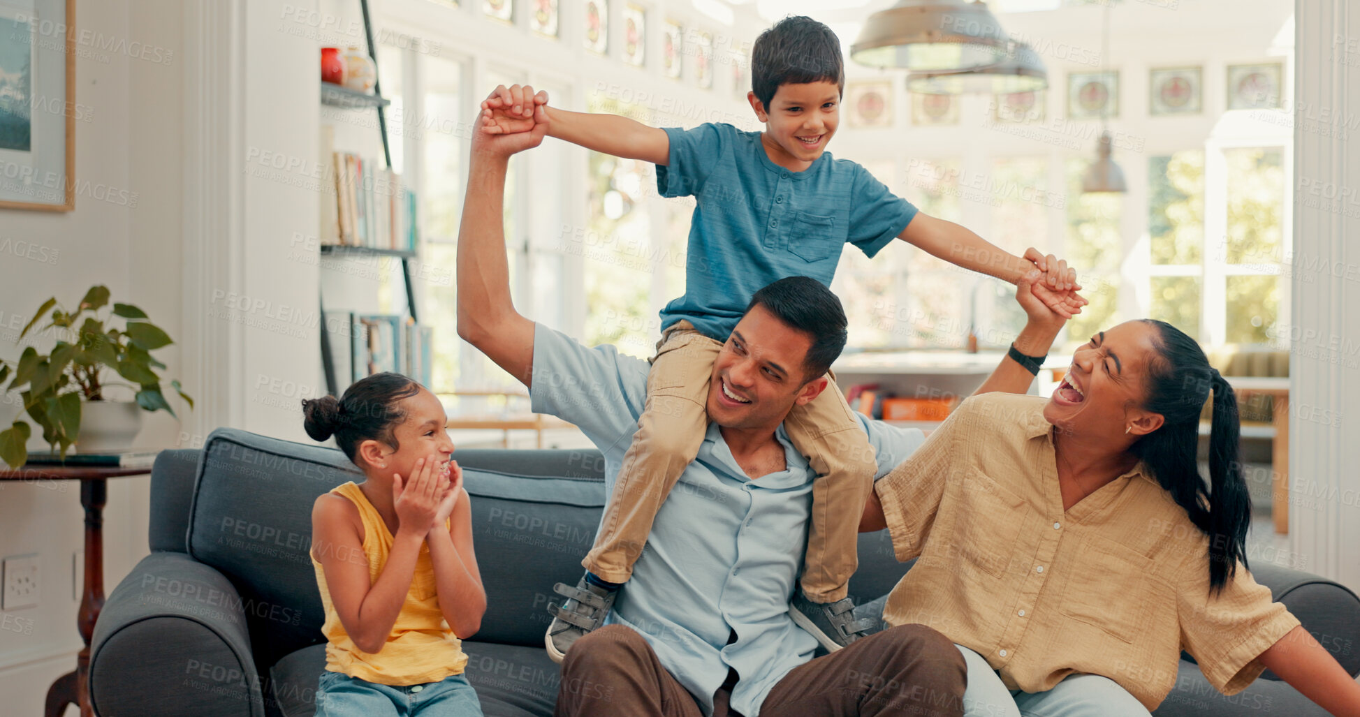 Buy stock photo Love, happy family and airplane fun on a sofa with care, security and support while bonding at home. Flying, balance and excited kids with parents in a living room for playing shoulder games together