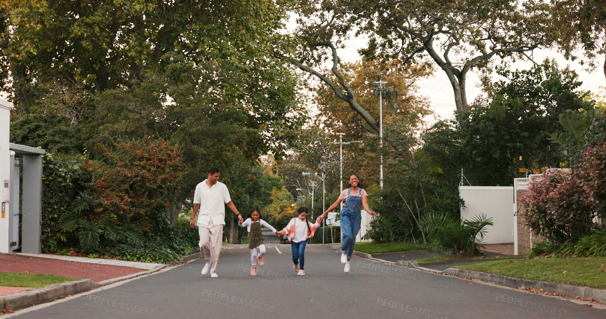 Buy stock photo Family, parents and kids in street, skipping and playful with love, care and holding hands in neighborhood. Vacation and children with walk, excited and playing in road in summer on school break