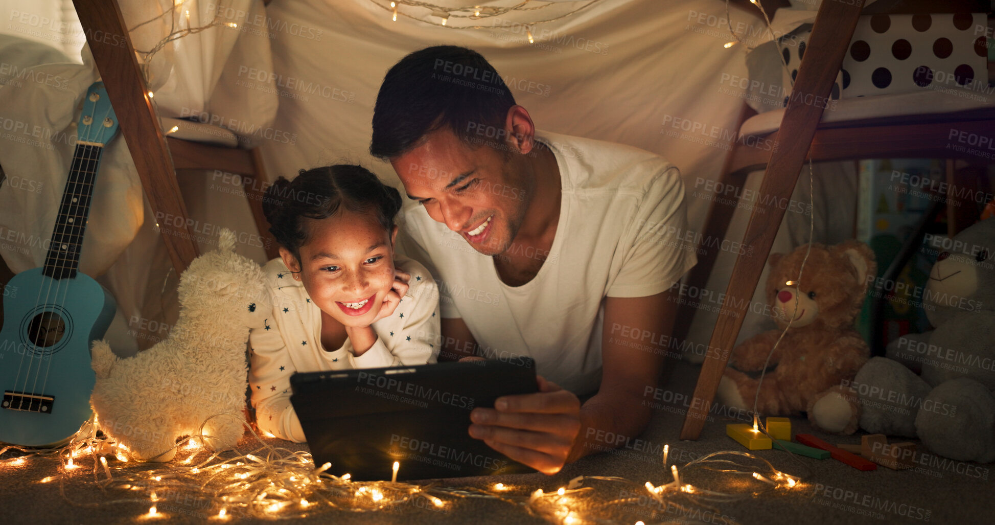 Buy stock photo Night, father and daughter with tablet for movie with streaming, blanket tent and sleepover with bonding, fairy lights and happy. Evening, dad and child with technology, pajamas and fun with cartoon