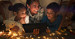 Funny, tablet and mother with children in a tent house streaming internet video, show or movie online in the night. Dark, digital and parent or dad relax with kids watching comedy in the evening