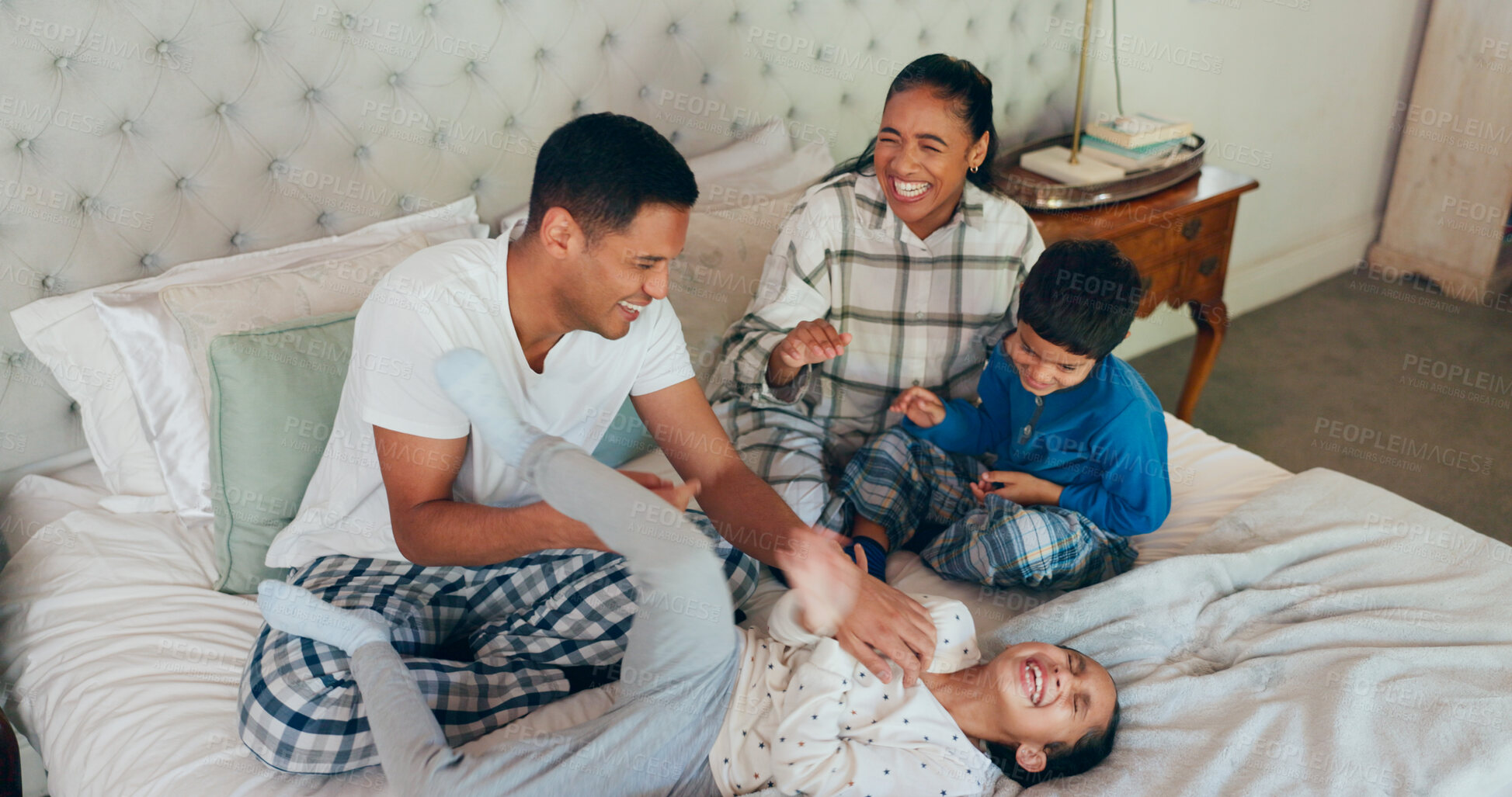 Buy stock photo Happy family, bed and playing with kids for love, bonding or fun morning together at the house. Mother, father and playful children with smile for crazy games, laughter or goofy parents in bedroom