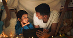 Night, father and boy on tablet in tent watching movies, online games and cartoon by blanket. Family, happy and dad with son and fairy lights in bedroom on digital tech for bonding, relax and love