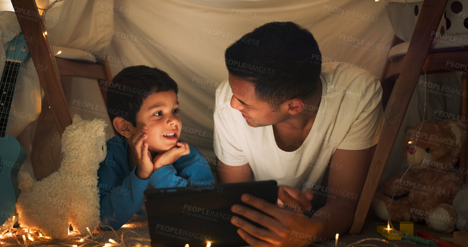 Buy stock photo Night, father and son with tablet for movie with streaming, blanket tent and sleepover with bonding, fairy lights and happy. Evening, dad and child with technology, pajamas and relax with cartoon fun