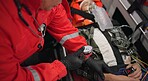 Watch, pulse and hands of a paramedic with a patient in an ambulance for rescue during an emergency or accident. Heartbeat, time and service with an emt closeup in a vehicle to save a man from above