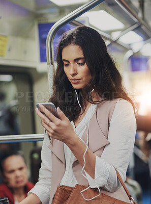 Buy stock photo Cropped shot of a young attractive woman using a cellphone while commuting with the train