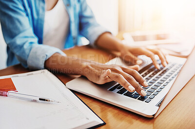Buy stock photo Shot of an unrecognizable young woman working on her laptop at home