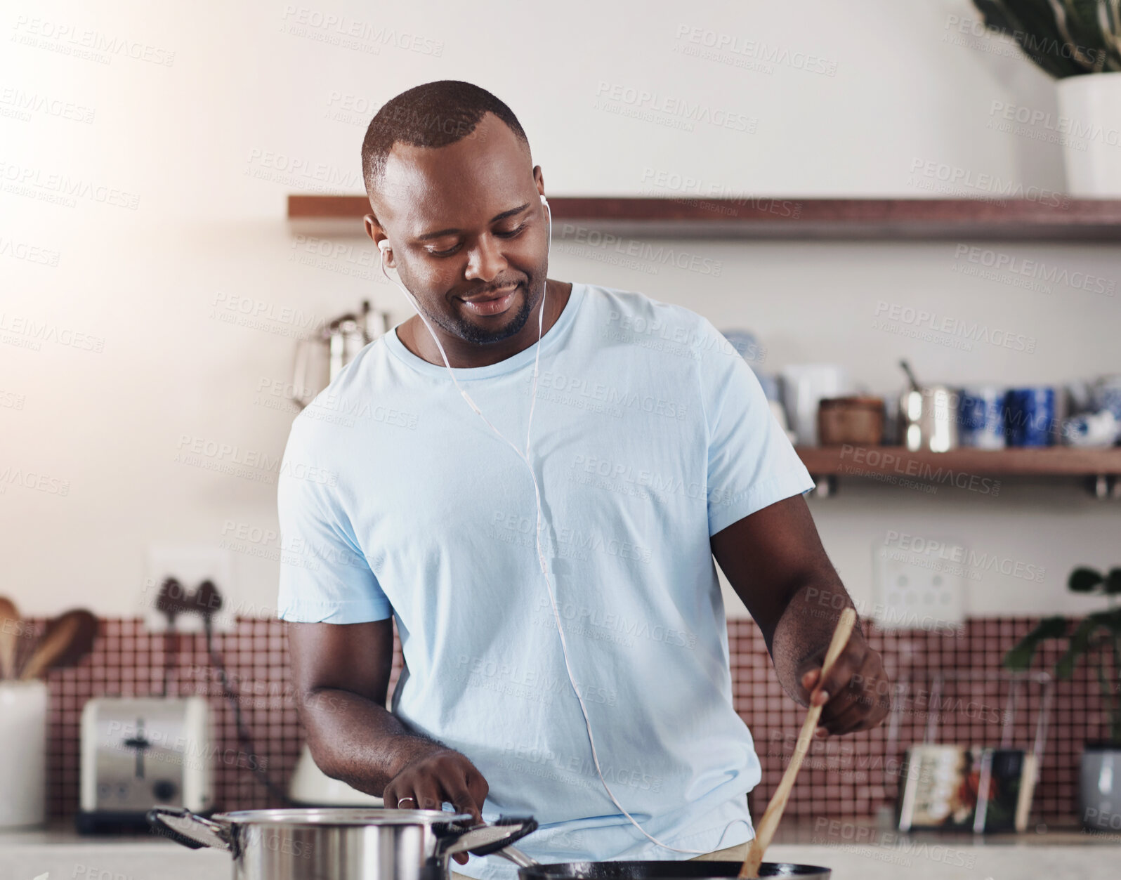 Buy stock photo Cooking, food and music with man in kitchen of home for diet, health or nutrition recipe. Ingredients, vegetables and wooden spoon with happy African person at apartment counter for meal preparation